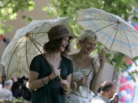 Zwei kostümierte, fröhliche Frauen mit Schirmen